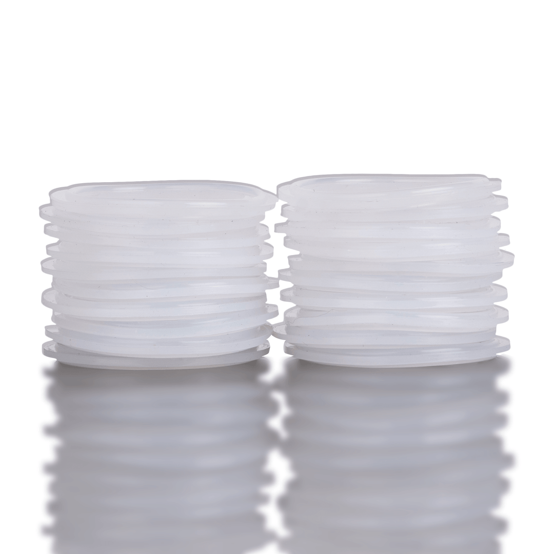 Two stacks of white silicone washers on a reflective surface with a white background