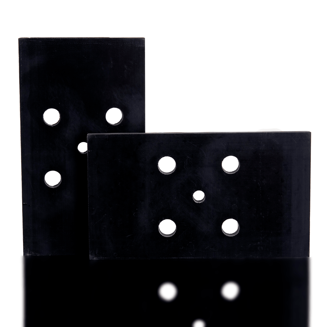 Two black sanding discs with holes on a white background