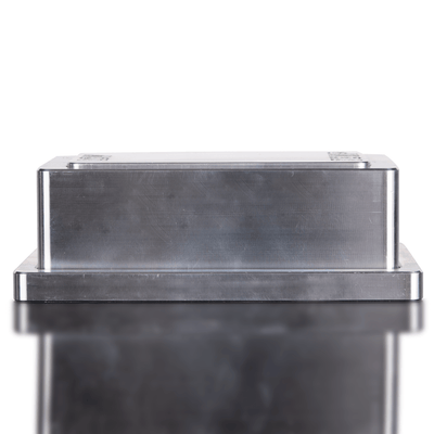 Metallic rectangular object on a reflective surface with a white background