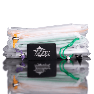 Stack of folded clothes with a Rosin Evolution branded card on a reflective surface