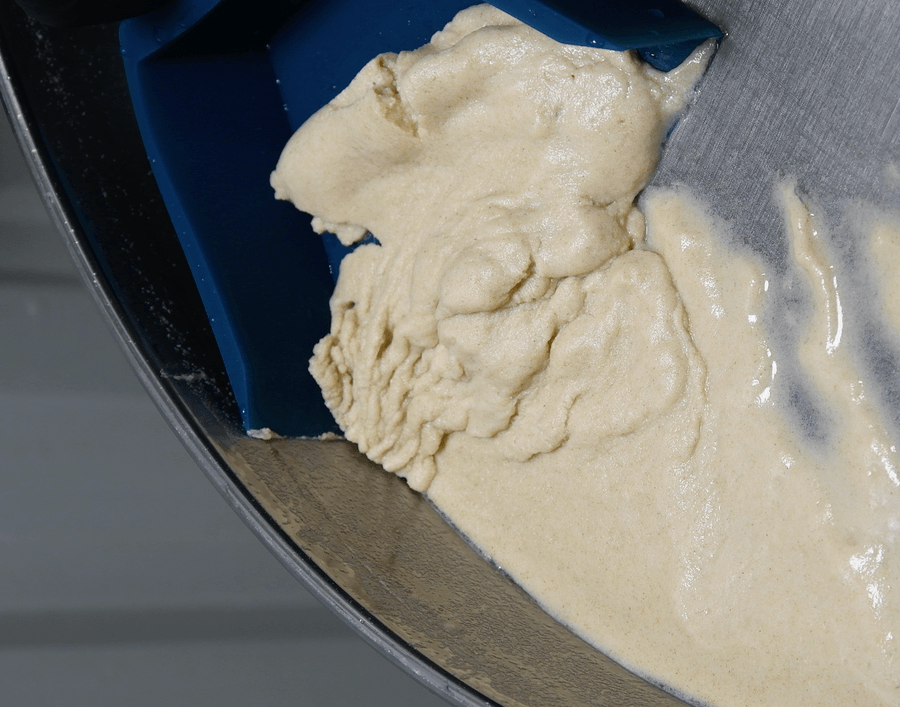 Mixer bowl with dough and a blue spatula