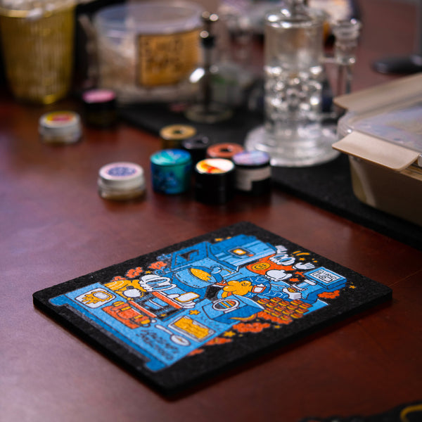 Colorful dab rig moodmat with cartoon design on a wooden surface